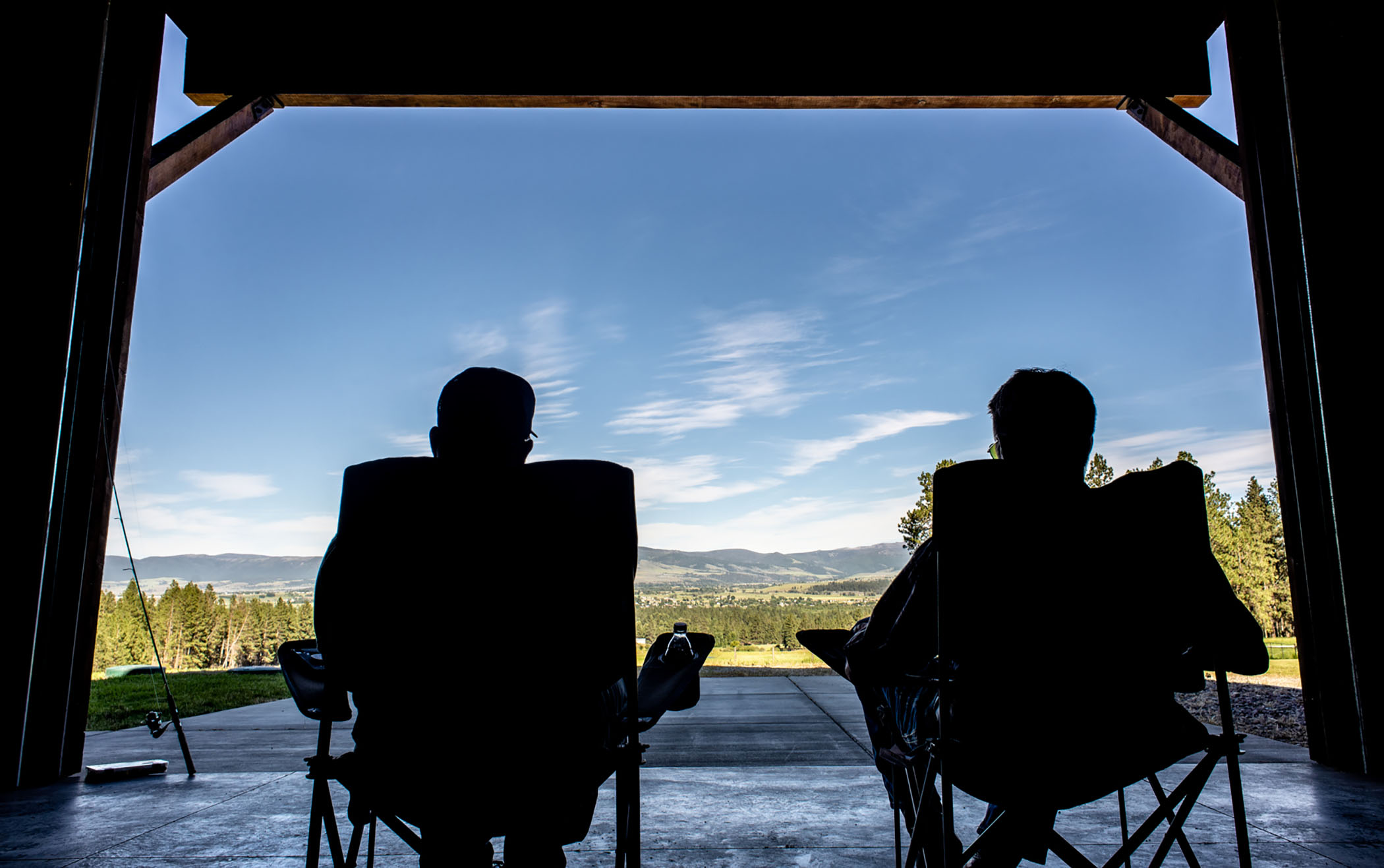 two men sitting in chairs outdoors