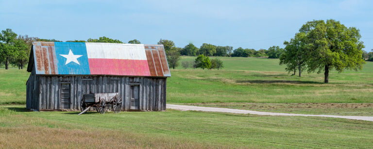 old barn with lone star flag