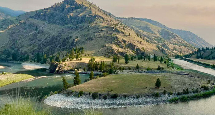 Off-Grid Base Camp to the Remote Idaho Wilderness Hits the Market for $6.75 Million river bends around a grassy plateau
