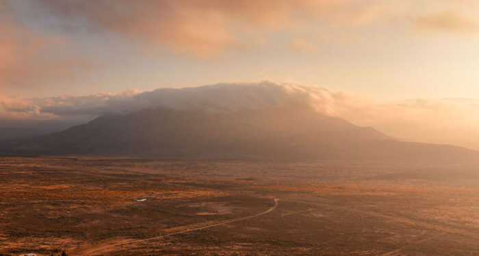 vistas in West TX of distant large plateau in clouds with homestead in foreground