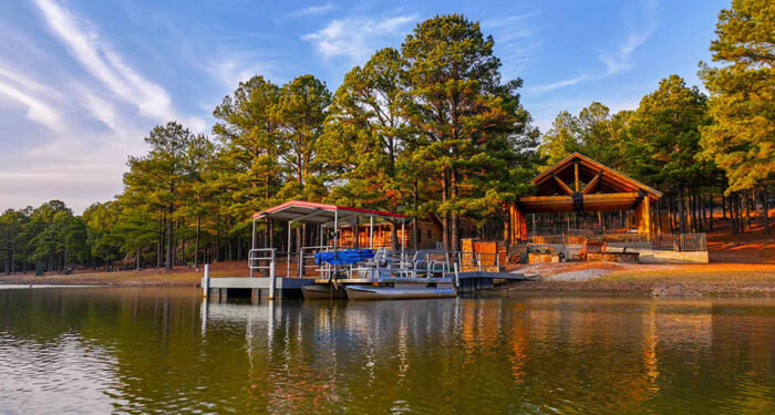cabin on edge of lake with dock and trees