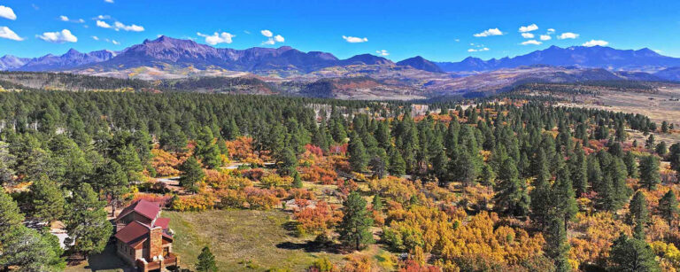 mountain home on expansive treed landscape with distant mountains