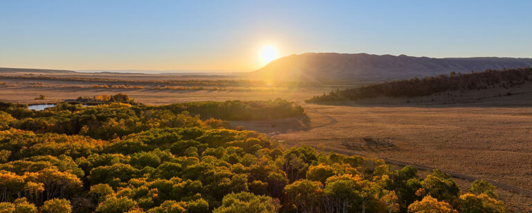 river bottom with distant setting sun and plateaus