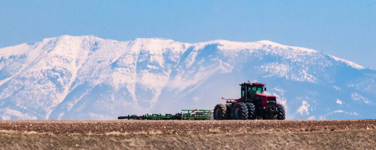 large snow-covered mountain with tractor on hill
