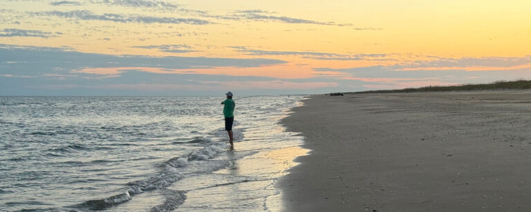 fishing off the beach at sunset