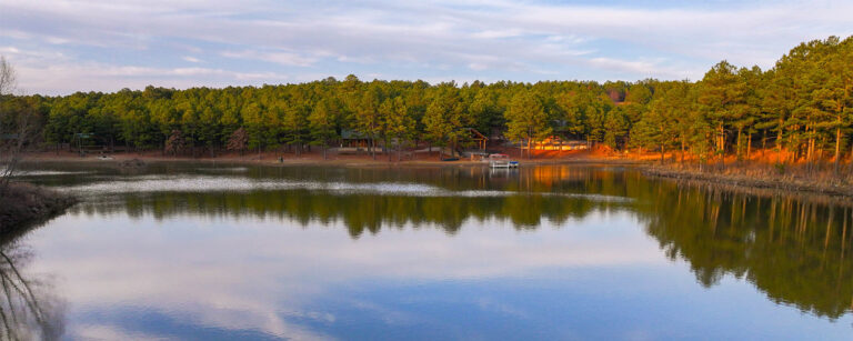 Large glassy lake with trees and boat dock