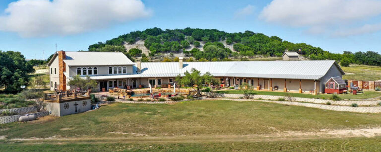 Large custom home with trees on a hill in the background