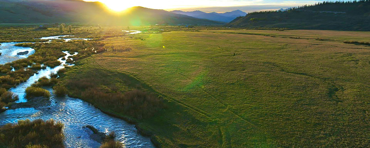 creek on the left of a sundrenched meadow on hoback ranch