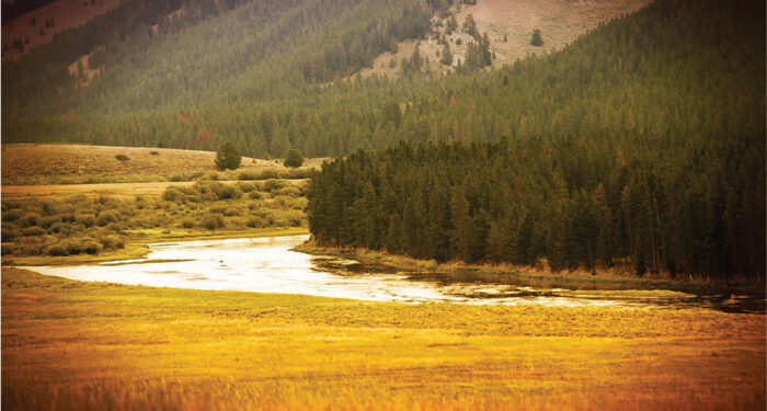 winding river through a mountain Valley with fall colors